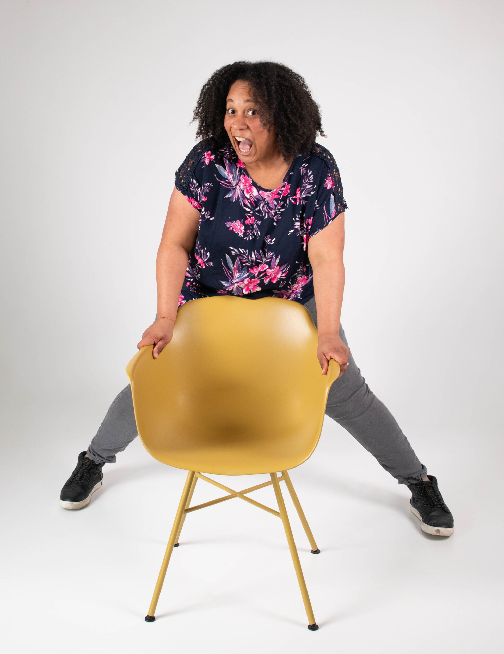 Gwendolyn Heath in een speelse pose achter een gouden stoel