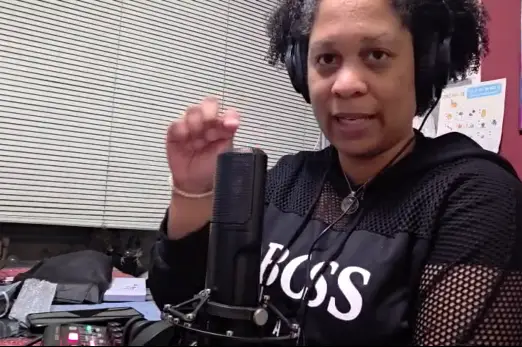 Gwendolyn Heath zit achter de microfoon tijdens een podcastopname