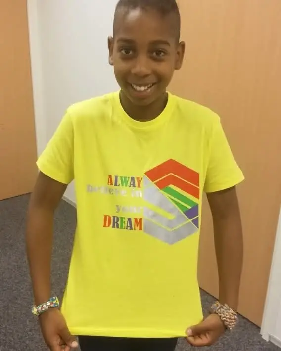 Sefon draagt een bedrukt shirt met de tekst Always believe in your dreams